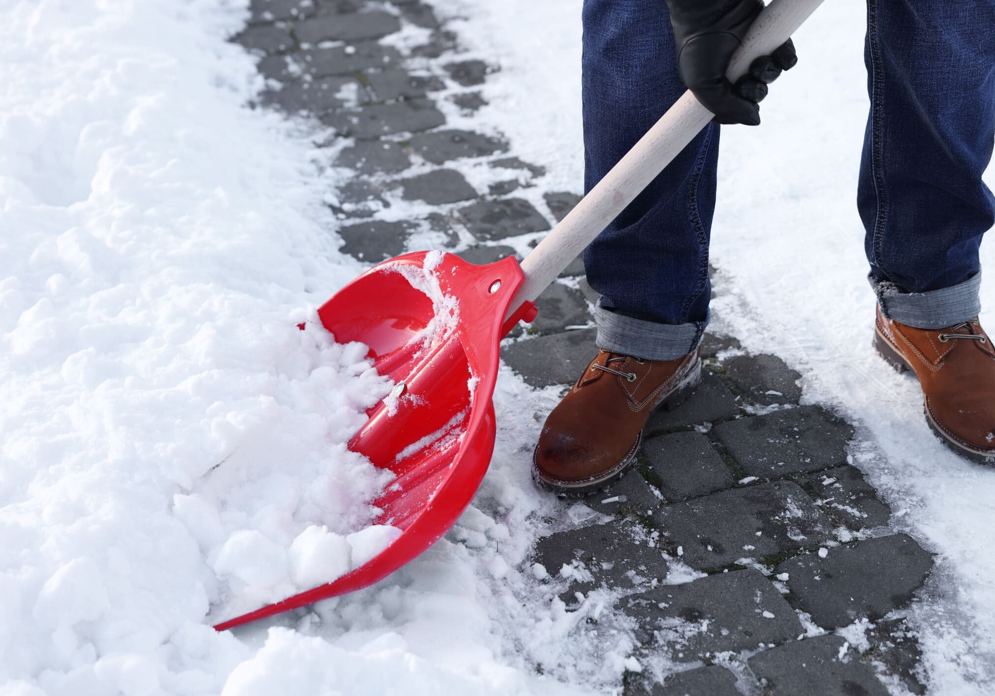 Shoveling snow off a paved path.